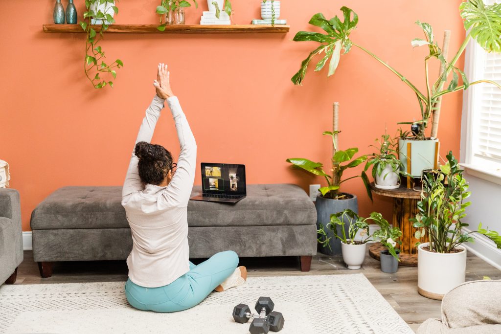 Doris stretching in front of her virtual group she is using a computer 